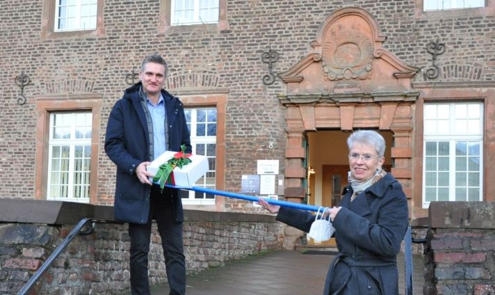 Marie-Theres Innecken-Prüss übergibt dem Niederzierer Bürgermeister Frank Rombey symbolisch ein Weihnachtspaket.